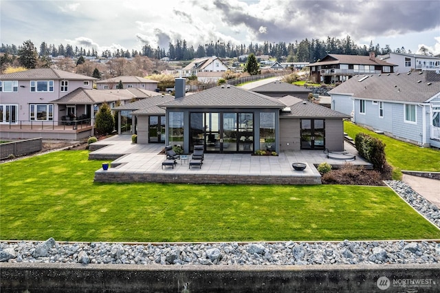 back of house featuring a residential view, a lawn, fence, and a patio area