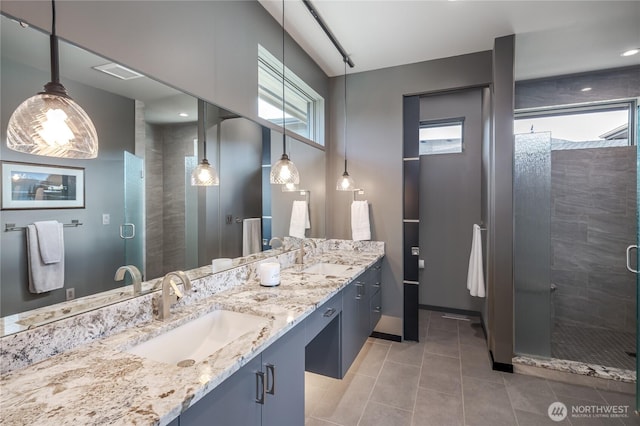 full bathroom with a shower stall, tile patterned floors, double vanity, and a sink