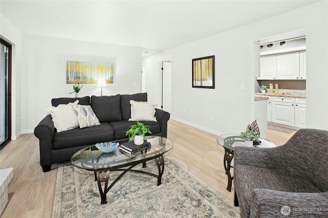 living room with light wood-type flooring and baseboards