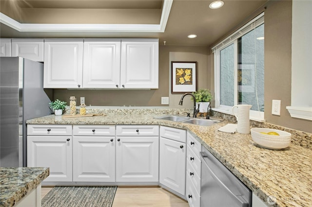 kitchen with light stone countertops, recessed lighting, white cabinets, stainless steel appliances, and a sink