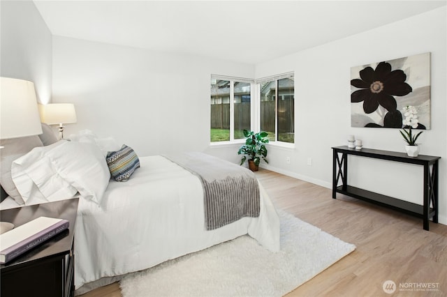 bedroom featuring wood finished floors and baseboards