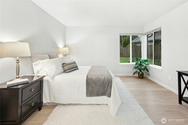 bedroom featuring baseboards and light wood-style flooring