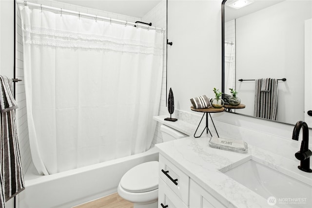 bathroom with shower / tub combo with curtain, wood finished floors, vanity, and toilet