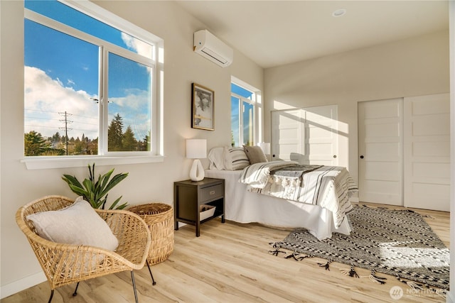 bedroom featuring wood finished floors and a wall mounted air conditioner