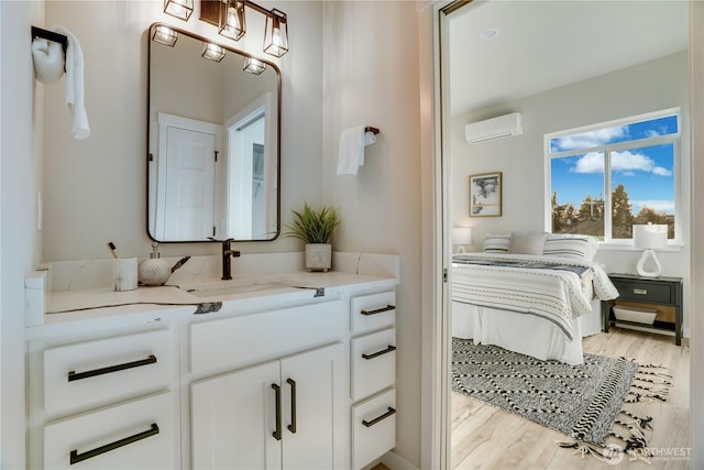 bathroom featuring an AC wall unit, wood finished floors, and vanity