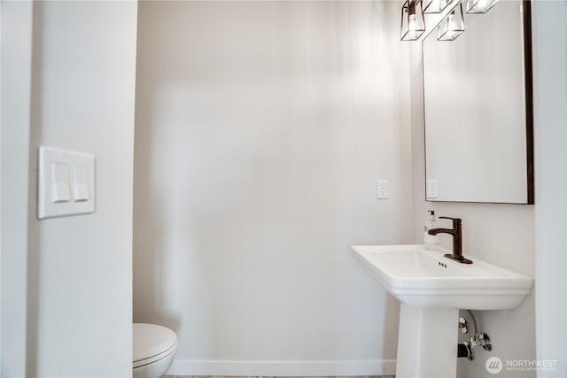 bathroom featuring baseboards and toilet