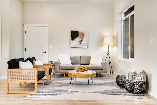 living area with baseboards and wood finished floors