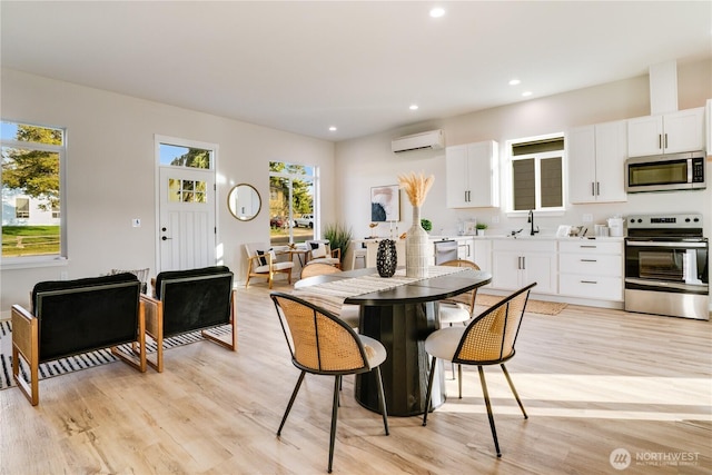 dining room featuring light wood-style floors, recessed lighting, and a wall mounted air conditioner