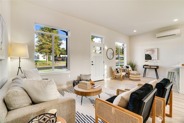 living area featuring light wood-type flooring, a wealth of natural light, a wall unit AC, and recessed lighting