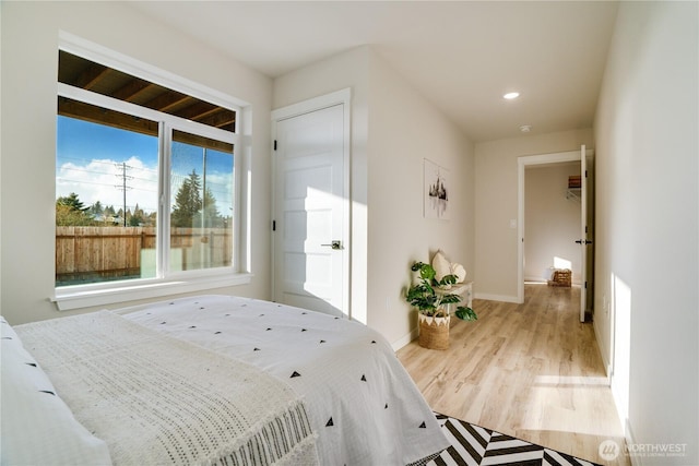 bedroom with light wood finished floors, recessed lighting, and baseboards