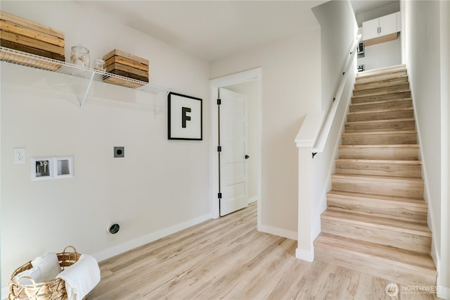 clothes washing area featuring laundry area, baseboards, hookup for a washing machine, hookup for an electric dryer, and light wood-style floors