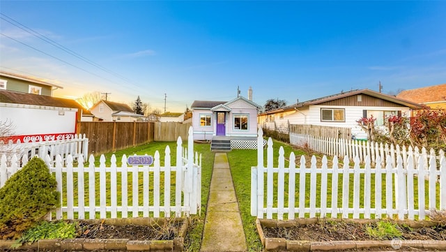 bungalow-style home featuring entry steps, a fenced front yard, and a front yard