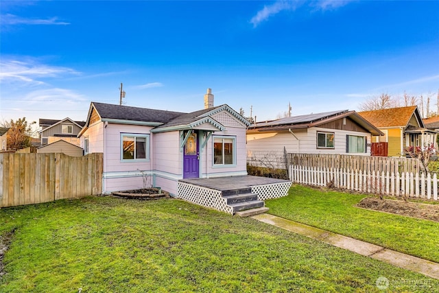 view of front of house featuring a wooden deck, a chimney, fence, and a front yard