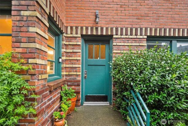 view of exterior entry featuring brick siding