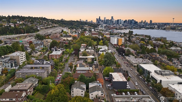 aerial view at dusk featuring a view of city and a water view