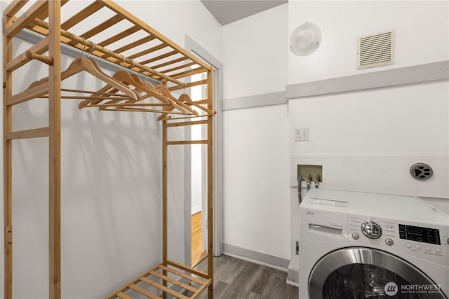 clothes washing area featuring washer / clothes dryer, visible vents, dark wood-style flooring, and laundry area