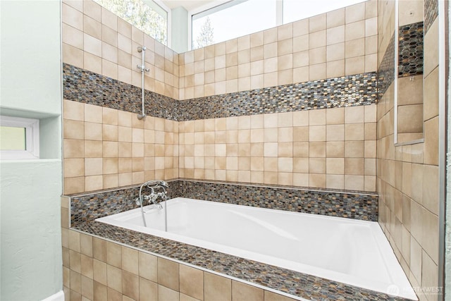 bathroom with tiled tub and a tile shower