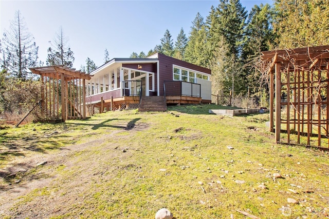 back of house featuring a sunroom, a yard, and a deck