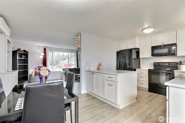 kitchen with light wood-style floors, black appliances, white cabinets, and light countertops