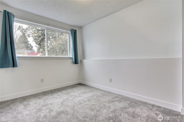 carpeted spare room with baseboards and a textured ceiling