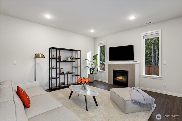 living room with recessed lighting, visible vents, wood finished floors, a tile fireplace, and baseboards