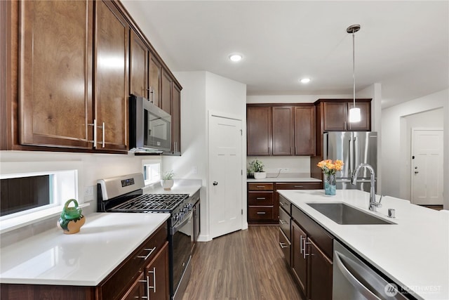 kitchen featuring dark wood-style floors, appliances with stainless steel finishes, light countertops, and a sink