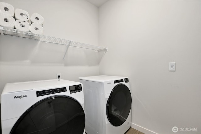 laundry room with laundry area, independent washer and dryer, baseboards, and wood finished floors