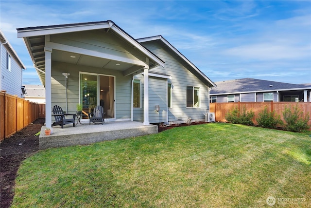 back of property with a patio area, a fenced backyard, and a lawn