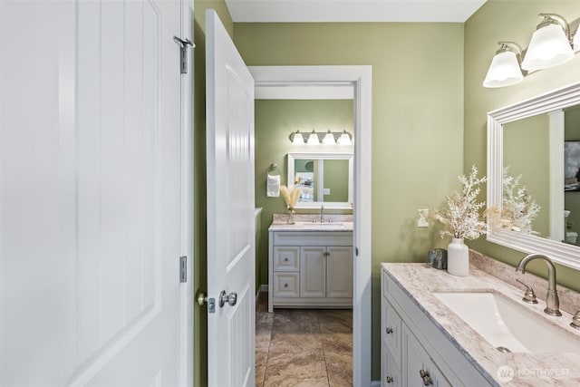 bathroom featuring two vanities and a sink