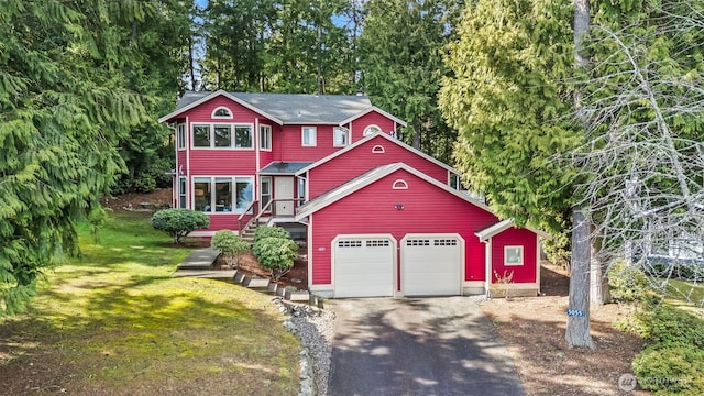 view of front of house featuring an attached garage, driveway, and a front yard