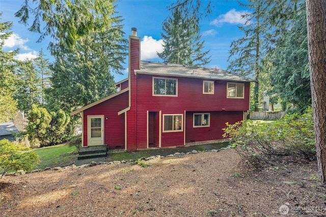 rear view of property with entry steps and a chimney