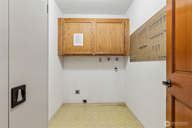 laundry room with cabinet space, electric dryer hookup, baseboards, and tile patterned floors