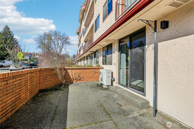 view of patio featuring ac unit and fence