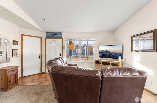 living area featuring light tile patterned flooring, light colored carpet, and lofted ceiling