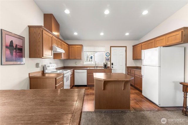 kitchen with a center island, under cabinet range hood, lofted ceiling, white appliances, and a sink