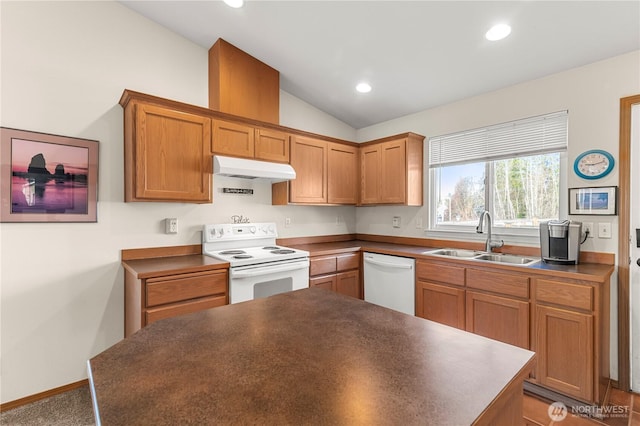 kitchen featuring a sink, under cabinet range hood, dark countertops, white appliances, and vaulted ceiling