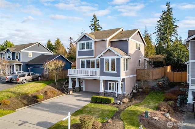 craftsman-style home with an attached garage, a shingled roof, fence, driveway, and stone siding