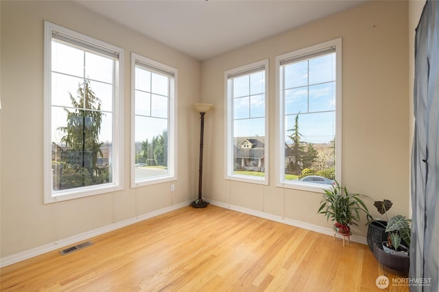 unfurnished room with visible vents, baseboards, and wood finished floors