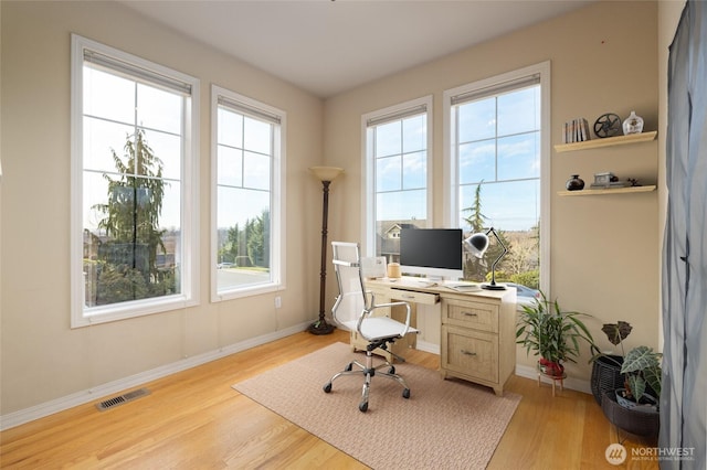 office area featuring visible vents, light wood-style flooring, and baseboards