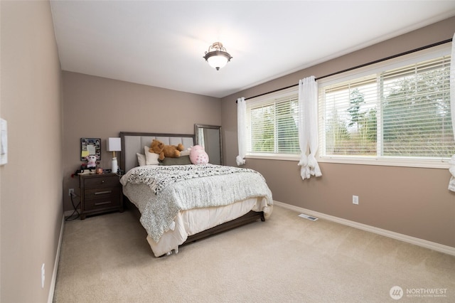 bedroom with light carpet, visible vents, and baseboards