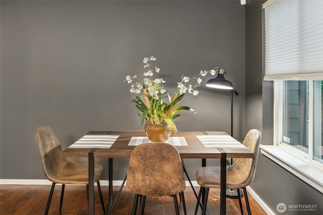 dining area with baseboards and wood finished floors