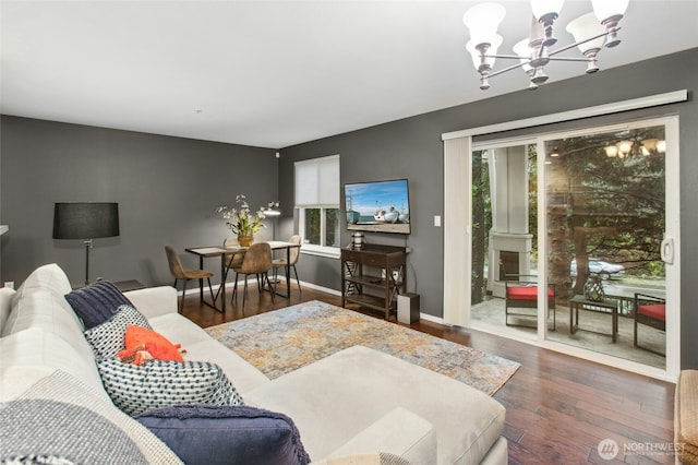 living area with a chandelier, wood finished floors, and baseboards