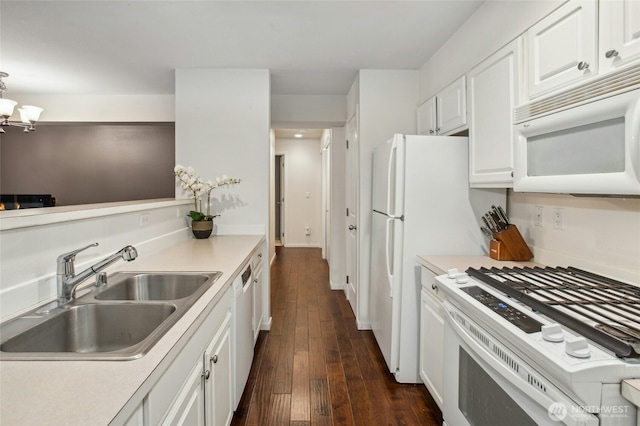 kitchen featuring white appliances, dark wood finished floors, light countertops, white cabinetry, and a sink