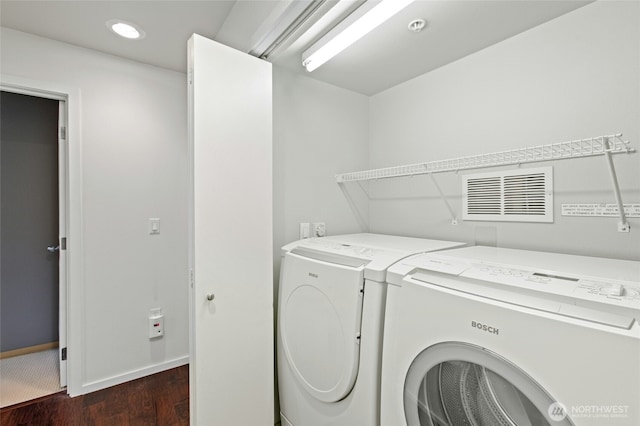 laundry room with laundry area, visible vents, baseboards, washer and clothes dryer, and dark wood finished floors