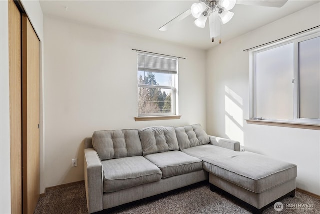 living area featuring carpet flooring, ceiling fan, and baseboards