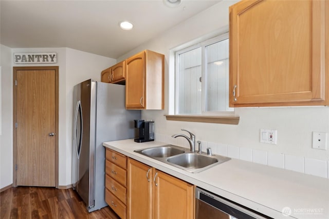 kitchen with recessed lighting, light countertops, dark wood-type flooring, appliances with stainless steel finishes, and a sink