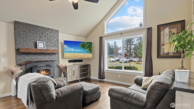 living area with a brick fireplace, baseboards, vaulted ceiling, and wood finished floors