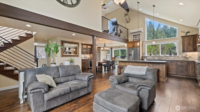 living room featuring dark wood-style floors, stairs, a wealth of natural light, and a wall mounted air conditioner