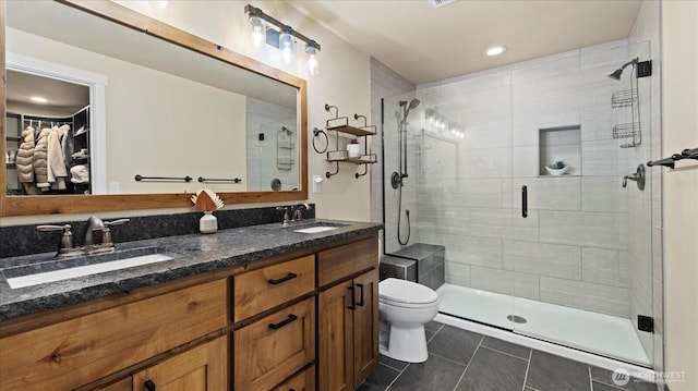 bathroom featuring a stall shower, a sink, toilet, and tile patterned floors