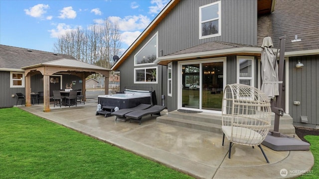 back of house featuring a yard, a shingled roof, a hot tub, entry steps, and a patio area